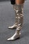 Street style outfit, woman wears silver shiny varnished block heels, over the knee boots