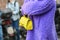 Street style, woman wearing a furry purple coat, yellow bag and purple sandals