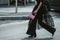 Street style, woman wearing puffy sleeves midi dress, high waist black flared pants, pink leather crocodile print pattern handbag