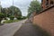 Street with trees and lawns in a residential area of a town on a cloudy day