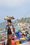 A street vendor carrying tray of freshly cooked yam, cassava and alike on her head