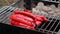 A street vendor frying sausages for hot dogs