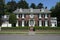 Street view of a brick colonial house in an affluent neighborhood