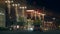 Street view in the evening with moving vehicles. Stock footage. Night view of decorative street lanterns and buildings