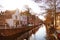 Street view with houses and canal in Delft, Holland at sunset