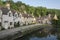 Street view of old riverside cottages in the picturesque Castle Combe Village, Cotswolds, Wiltshire, England - UK