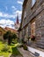 Street and wooden wall of a house and spire of medieval Lutheran church