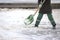 Street worker shovels snow from the sidewalk