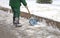 Street worker shovels snow from the sidewalk