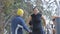 Street workout training. Hispanic woman taking initial position on parallel bar with help of three people on fitness