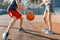 Streetball basketball game with two players, teenagers girl and boy with ball, outdoor city basketball court