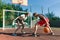 Streetball basketball game with two players, teenagers girl and boy, day on basketball court