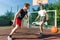 Streetball basketball game with two players, teenagers girl and boy, morning on basketball court