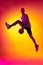 Streetballer. Male basketball player, athlete jumping with ball  on gradient yellow orange background in neon