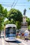 A streetcar is driving down La Canebiere, passing by the 1870`s war memorial in Marseille, France