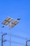 Streetlight post and solar power panels with electric poles against blue clear sky background