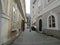 The streets of medieval Bohemia - paving stones, walls of wild stone, crooked streets. The clock on the city tower.