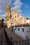 Streets of the medieval town of La Iglesuela del Cid with the Church of Purification in the background on a blue day with clouds,