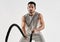 Strength comes from an indomitable will. Studio shot of a muscular young man exercising with battle ropes against a