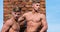Strength and grace. Men muscular athlete bodybuilder show muscles. Men muscular chest naked torso stand brick wall