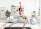 Strength yoga exercises. Millennial black lady standing in warrior asana, exercising on sports mat at home