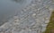 Strengthening of the banks lined with stones against water erosion on the river. The water dam on the pond is reinforced by gray b