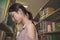 Stress asian studentwoman standing in between bookshelves