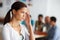 Stress-based illness in the workplace. a young female professional with her hand to her temple looking in pain with