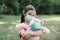 Stress little girl holding toy bear in medical protective mask