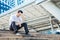 The stress man sitting alone on the stair outdoor. Young business man crying abandoned lost in depression