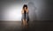 Stress and psychological problems. A young teenage girl is sitting on the floor in a room with her hands clasped behind her head.