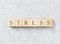 Stress word made with wooden blocks on grey background