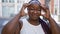 Stressed african american woman with braids, feeling headache ache on urban street, showcasing despair expression