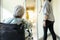 Stressed asian senior woman sit in wheelchair peeking out the door at hospital corridor,elderly patient feel afraid ,anxious to