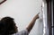 Stressed asian woman is pointing at the cracks,rift of wall in her house,collapsed after repair or extension of substandard