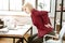 Stressed blonde woman having extreme backache at work