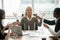 Stressed businesswoman meditating at meeting with diverse employ