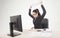 Stressed businesswoman sitting at table in front of computers.