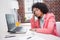 Stressed casual businesswoman sitting at desk