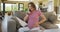 Stressed caucasian pregnant woman sitting on sofa, touching belly and having call