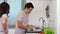 Stressed couple conflict in their kitchen, angry woman pointing hand to man for washing dishes