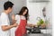 Stressed couple conflict in their kitchen while cooking and preparing food