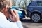 Stressed Driver Sitting At Roadside After Traffic Accident