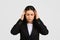 Stressed european businesswoman in suit touching her temples, displaying signs of headache or intense concentration