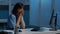 Stressed exhausted medical assistant standing at desk working after hours