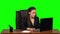 Stressed female enthusiastically works behind a laptop and very angry. Green screen. Slow motion