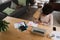 Stressed female student studying for online exam sitting in modern kitchen with coffee and stationary.