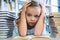 Stressed girl with head in hand at school library