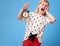 Stressed modern child in red pants on blue with alarm clock