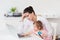 Stressed Mother With Child Using Laptop At Home